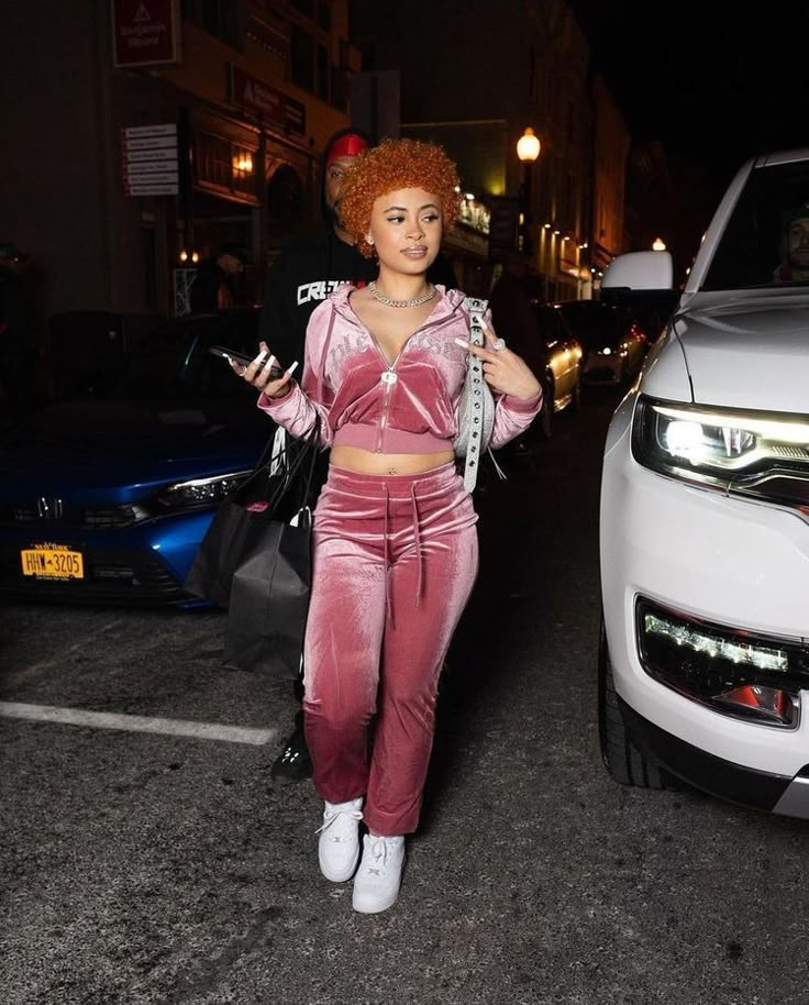 a woman with red hair is walking down the street