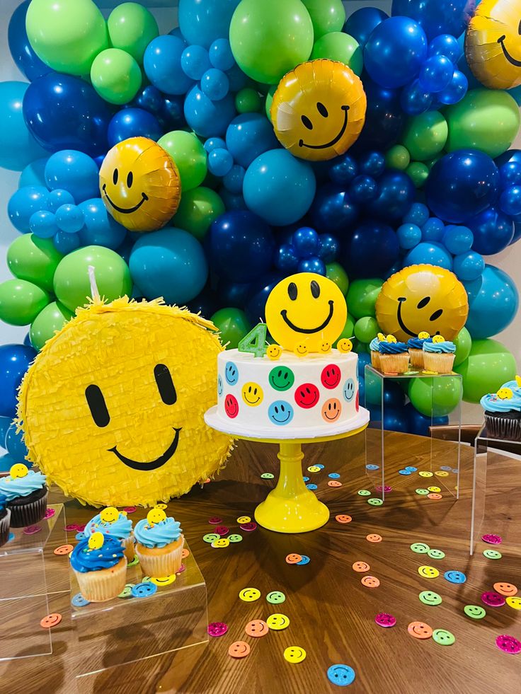 a table topped with a cake and lots of balloons