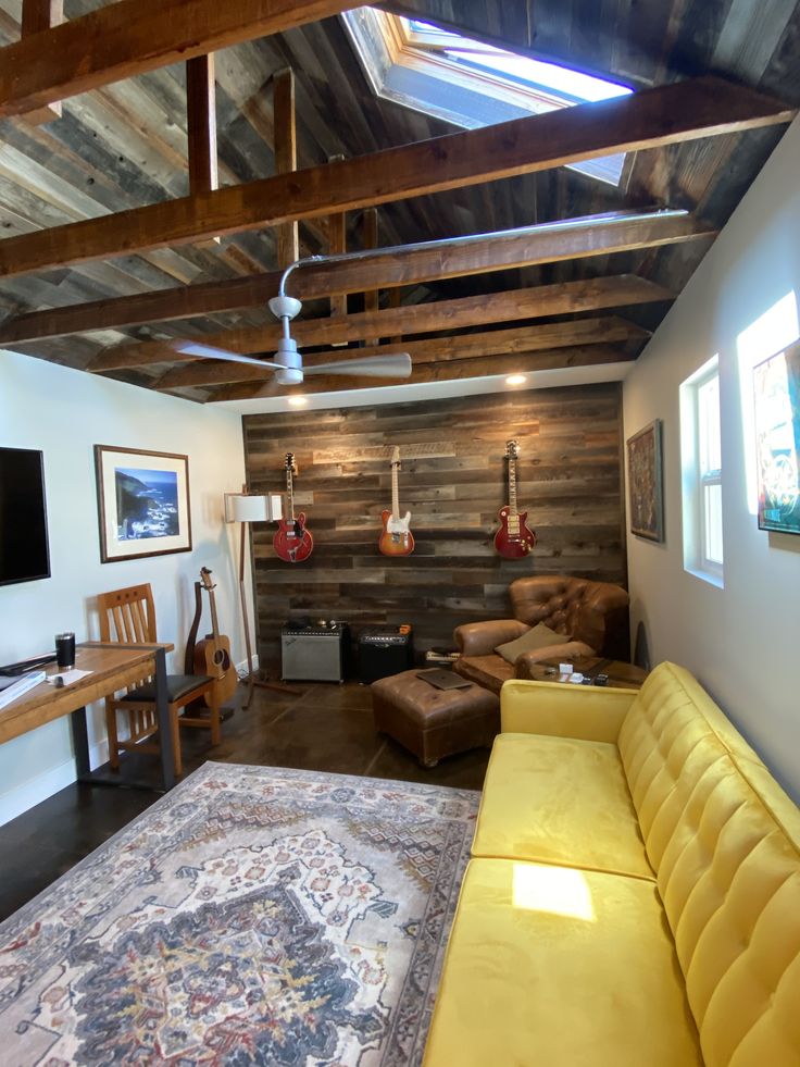 a living room filled with furniture and a flat screen tv on top of a wooden wall