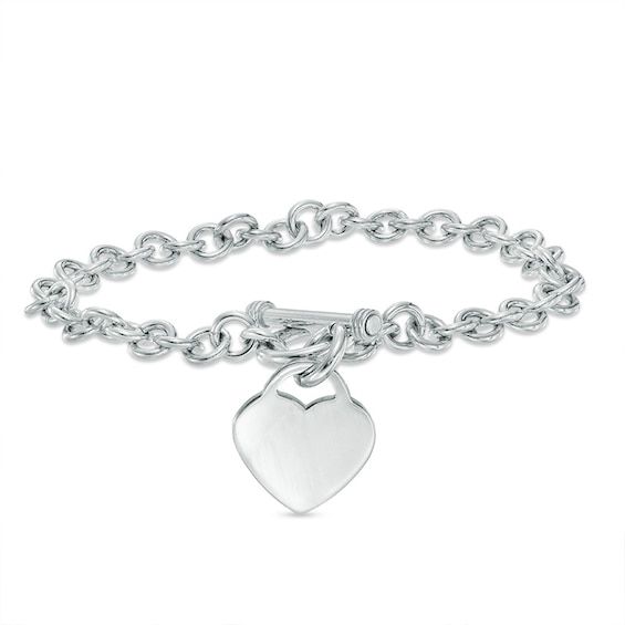 Simple, meaningful and so stylish, this darling heart charm bracelet is certain to win hers. Fashioned in sleek sterling silver, this rolo chain bracelet is finished with a lovely heart-shaped dangle charm. A look she'll treasure, this 7.25-inch bracelet is polished to a brilliant shine and secures with a toggle clasp. Zales Jewelry, Cheap Silver Rings, Toggle Bracelet, Stacked Jewelry, Jewelry Lookbook, Colorful Jewelry, Girly Jewelry, Rolo Chain, Dream Jewelry