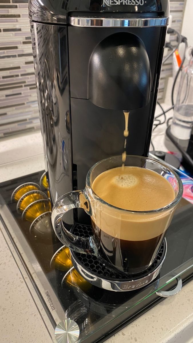 a cup of coffee is being poured into the espresso machine