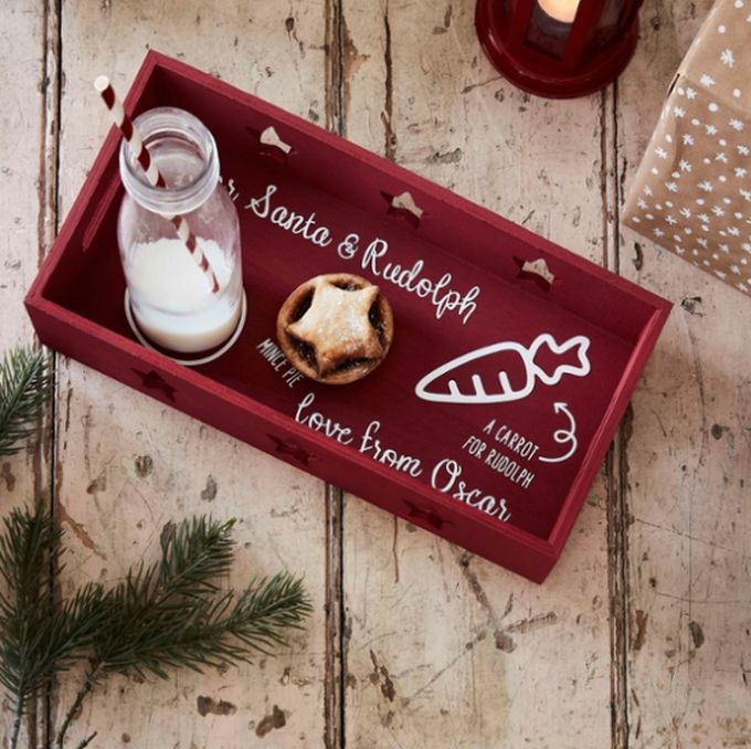 a tray with some food on top of it next to a candle and christmas tree