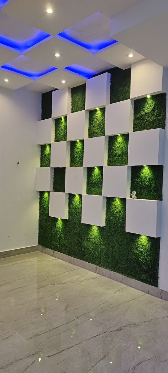 a room with white walls and green plants on the wall, along with blue lights