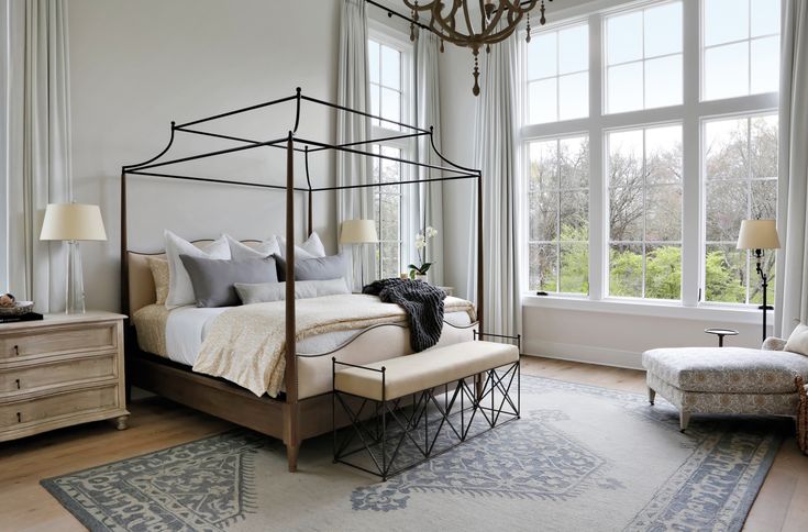 a bedroom with a four poster bed and white walls