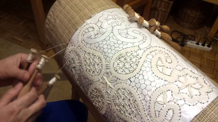 someone is working on an intricately designed cushion