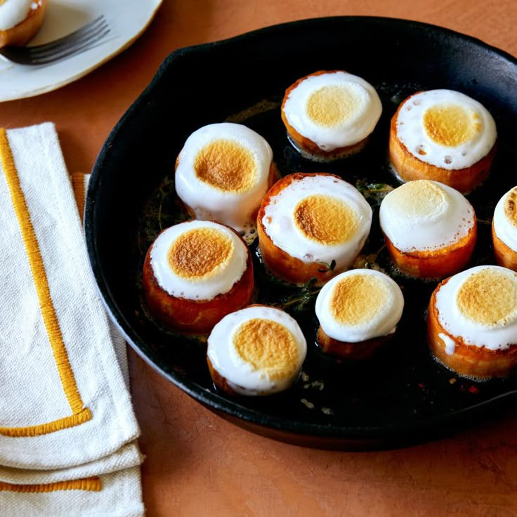 an iron skillet filled with eggs on top of a wooden table