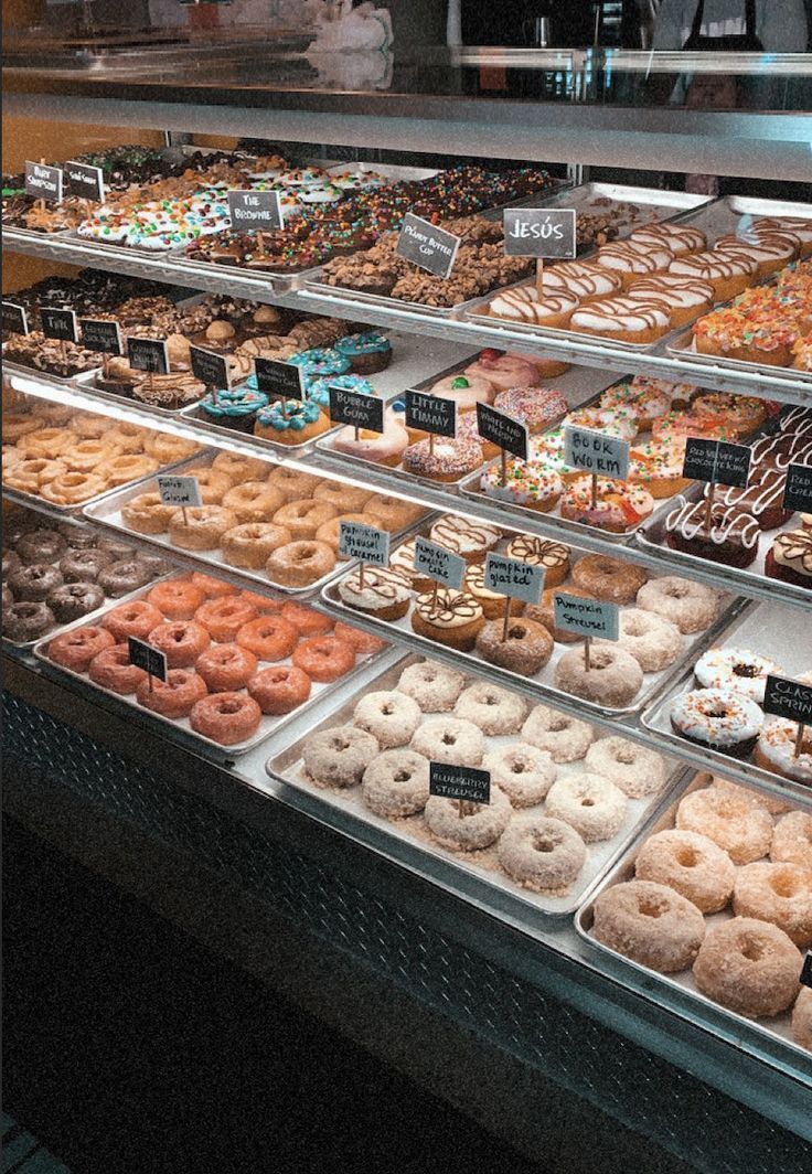 a display case filled with lots of different kinds of doughnuts and pastries