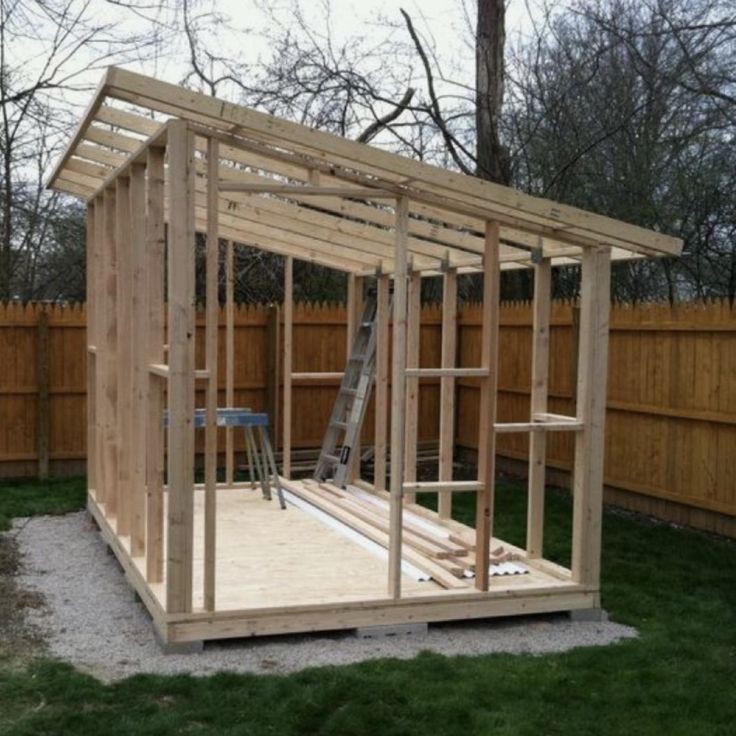 a small wooden structure in the middle of a yard