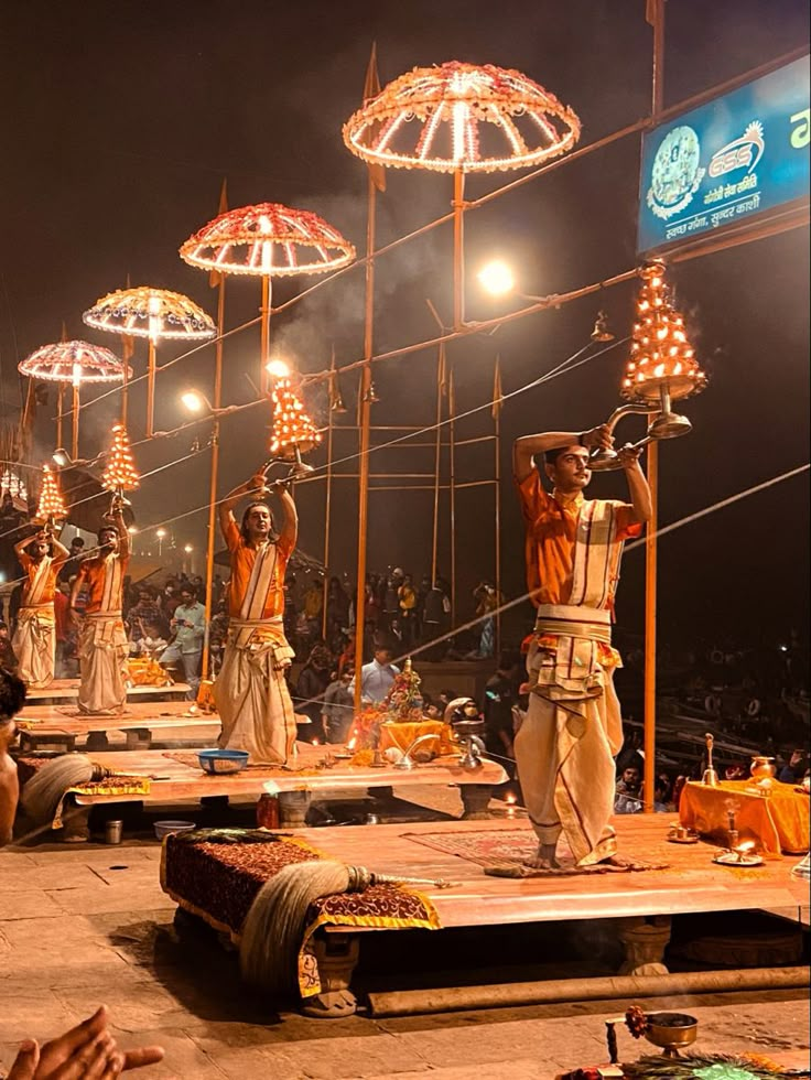 some people are performing on stage with umbrellas in the air and lights above them