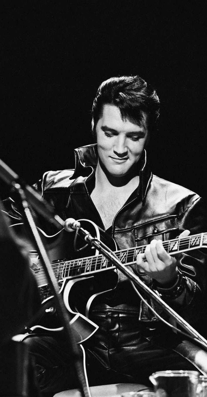 a black and white photo of a man playing an electric guitar