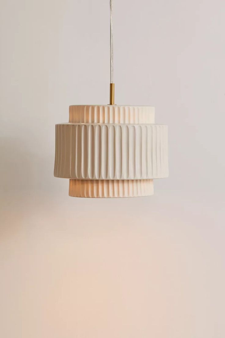 a white lamp hanging from a ceiling with a light fixture attached to it's side