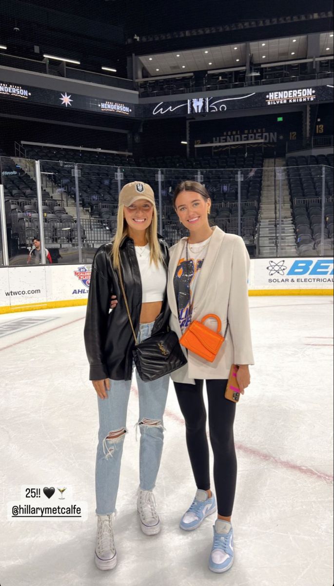 two women standing next to each other on an ice rink