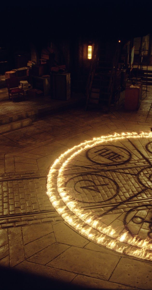 a man riding a skateboard on top of a sidewalk covered in string lights at night