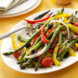 a white plate topped with green beans, peppers and onions on top of a yellow table cloth