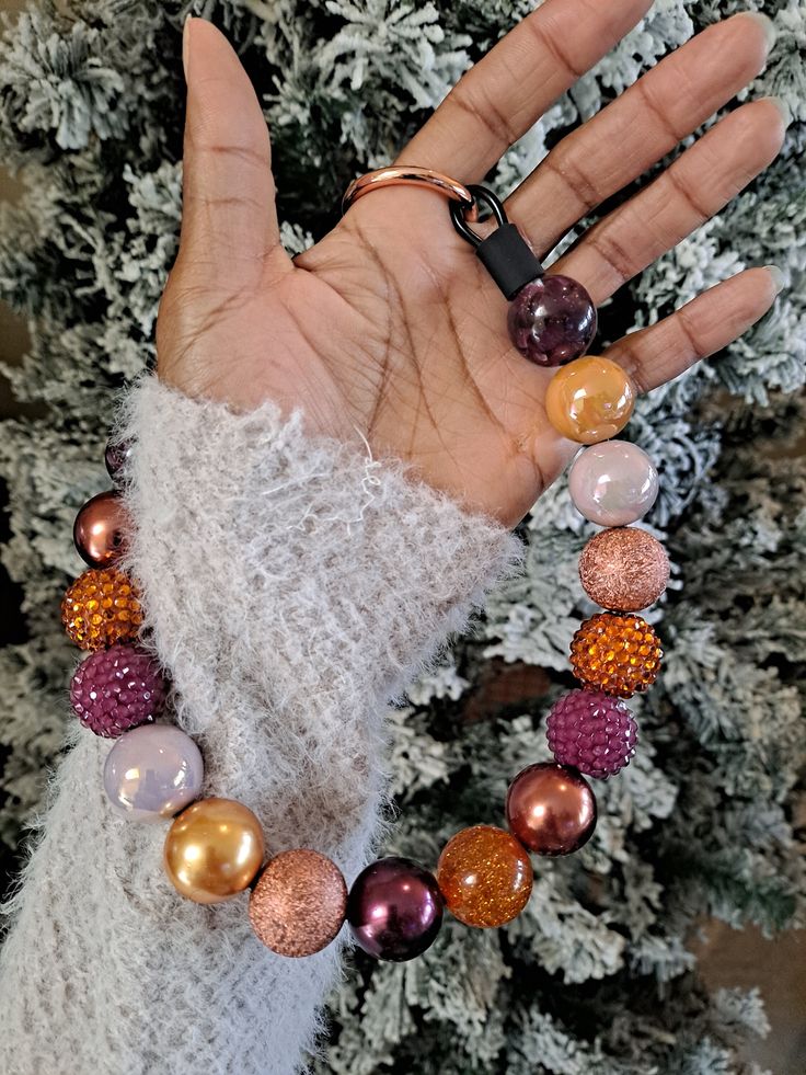 a woman's hand wearing a bracelet with multicolored beads