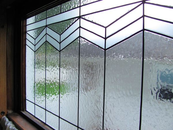 a close up of a stained glass window with rain coming down on the windowsill