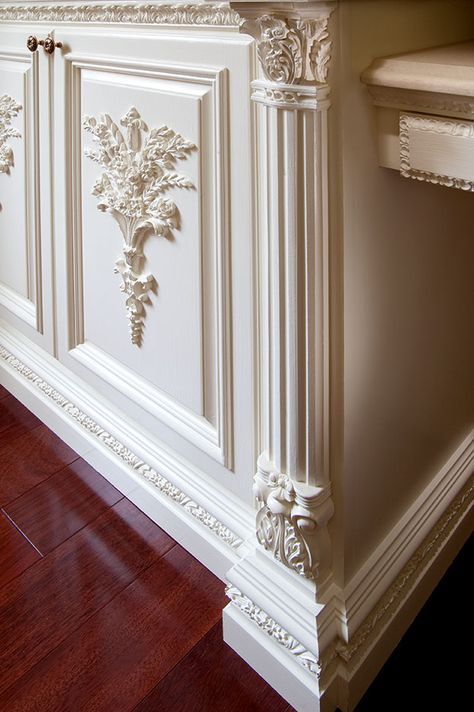 an ornately decorated kitchen with wood flooring and white cabinetry on the wall