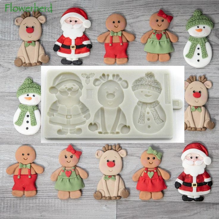 christmas cookie molds with santa, snowman and other holiday decorations on a table