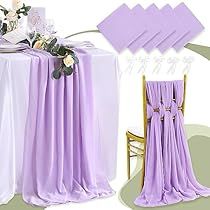 the table is covered with purple cloths and flowers