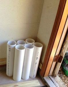 four white pipes sitting next to each other in front of a door