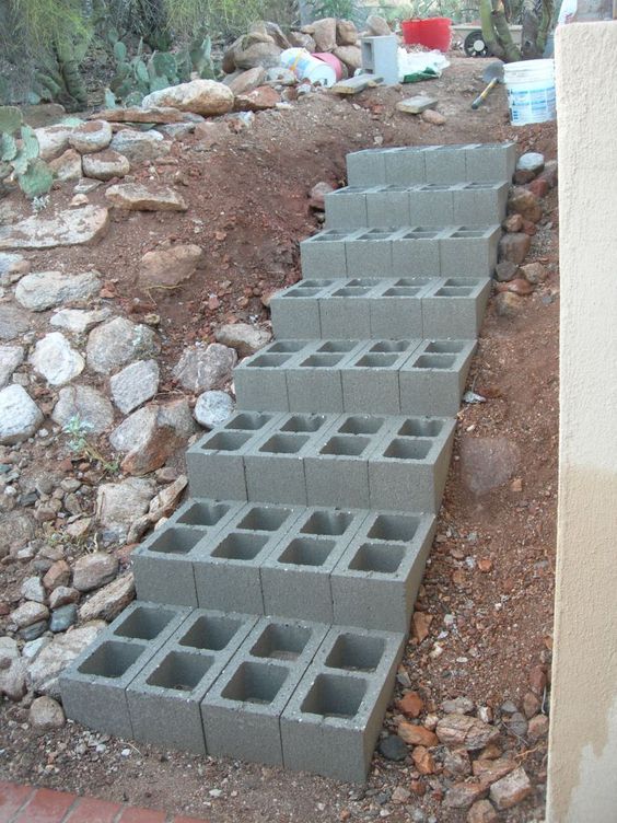 several cinder blocks stacked on top of each other in front of rocks and dirt area