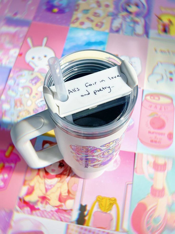 a coffee cup with a note attached to it on a colorful tableclothed surface