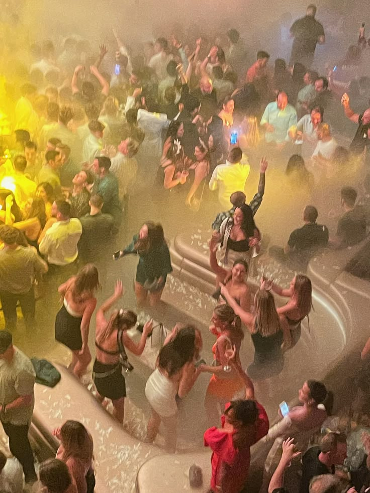 a group of people standing in front of a fire hydrant filled with water at a party