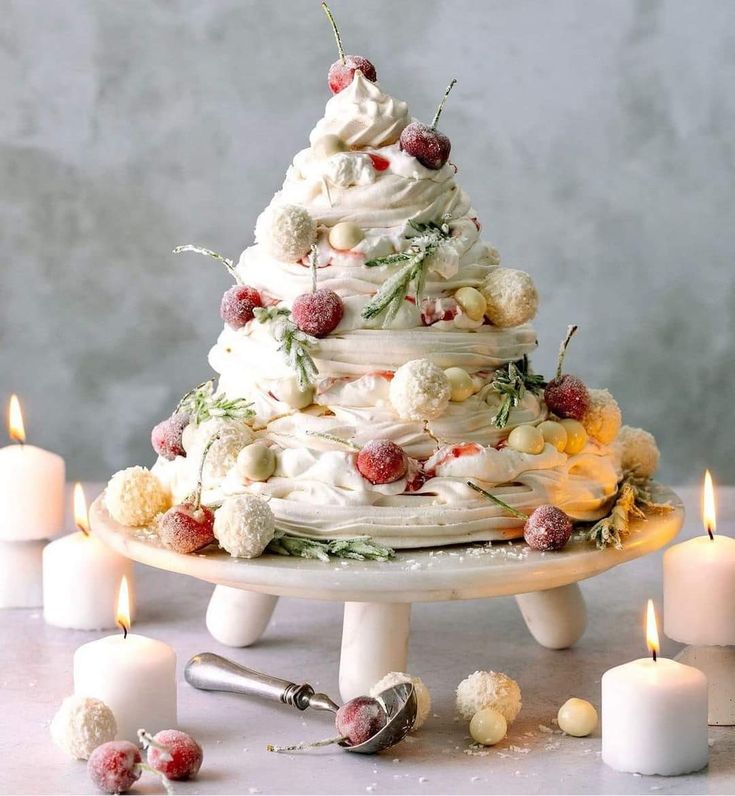 a white cake sitting on top of a table next to candles