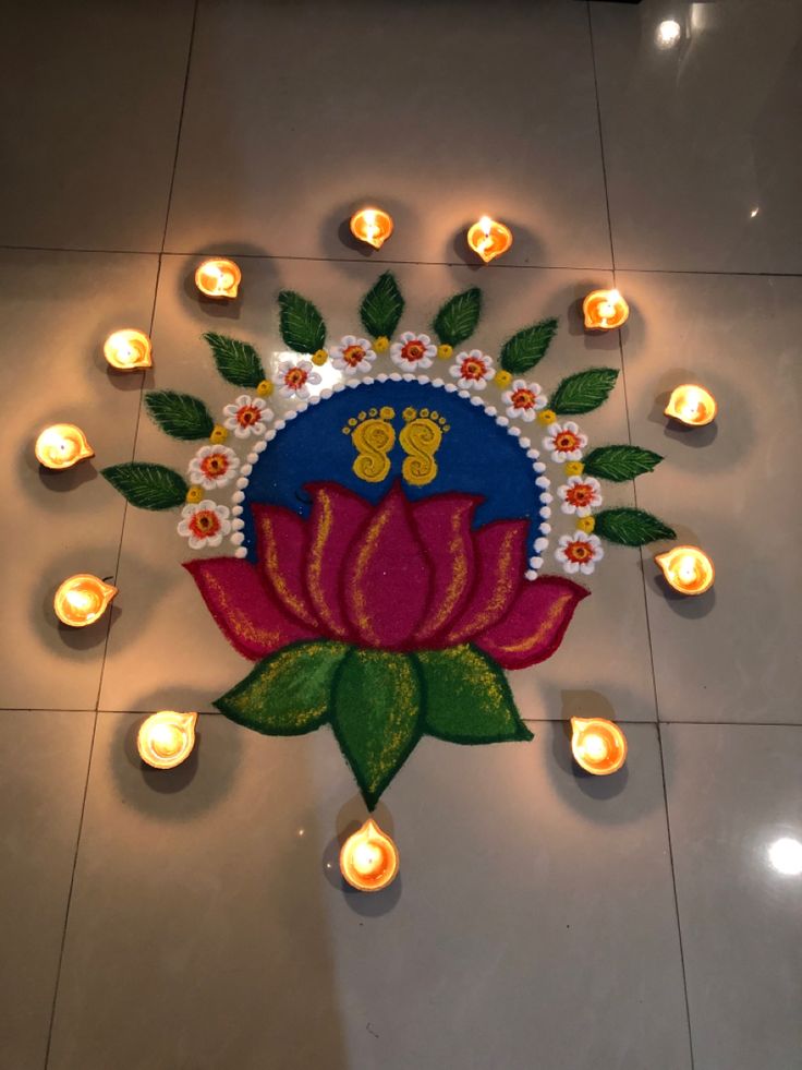 lighted diya with flowers and candles on the floor