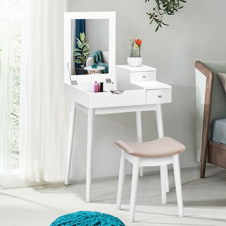 a white desk with a mirror and chair in a room next to a plant on the wall