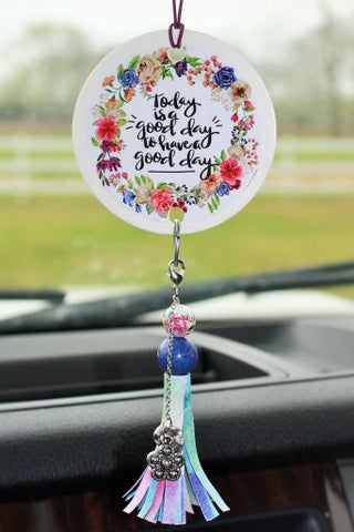 a car dashboard decoration with flowers and tassels hanging from it's dash board