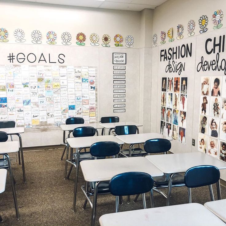 an empty classroom with desks and chairs in front of a bulletin board that says goals