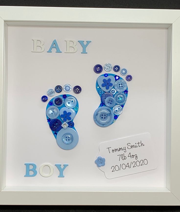 a baby's hand and foot print is displayed in a white frame with blue buttons