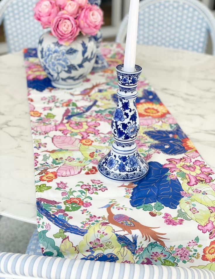 a blue and white vase sitting on top of a table next to a candle holder