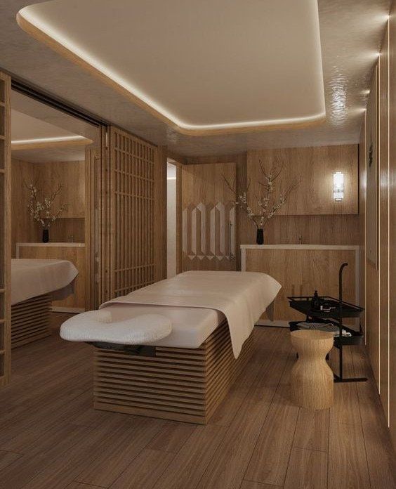 a spa room with two massage tables and wooden walls on either side of the room