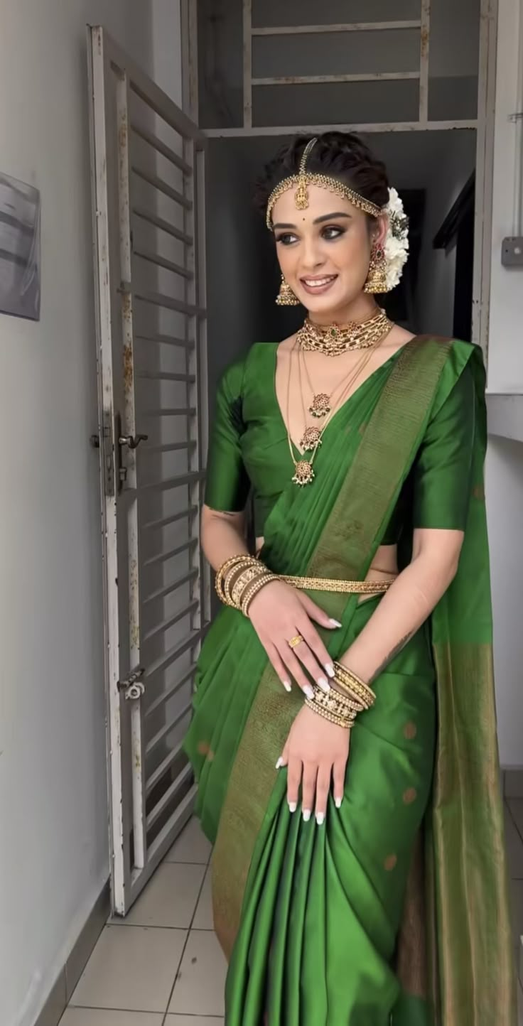 a woman in a green sari and gold jewelry