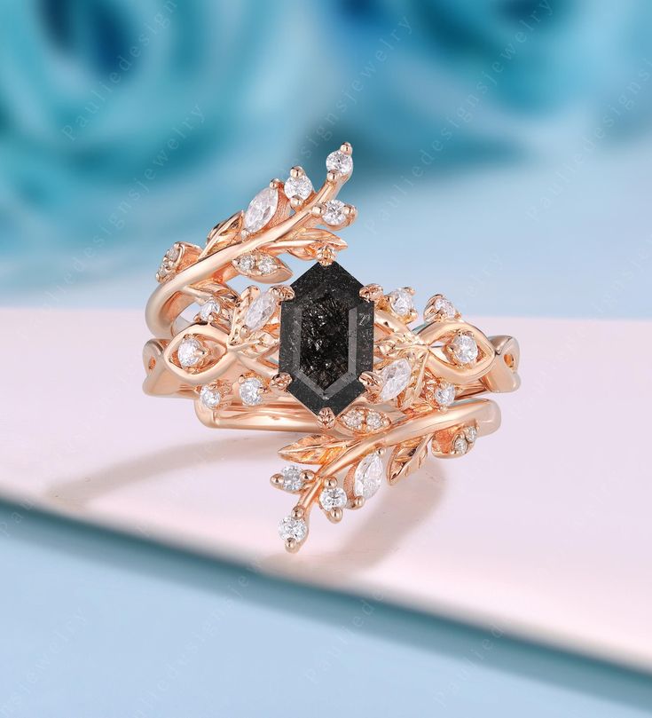 a close up of a ring with a black stone in the center and white diamonds on it