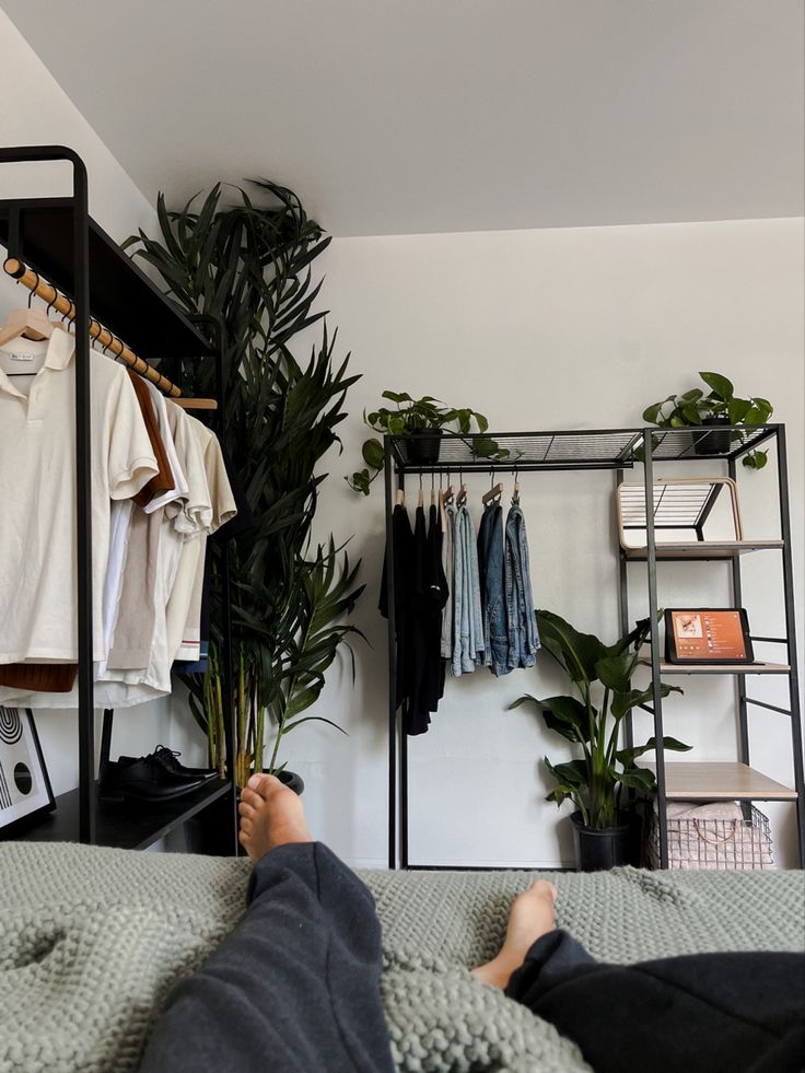 a person laying on a bed next to a plant