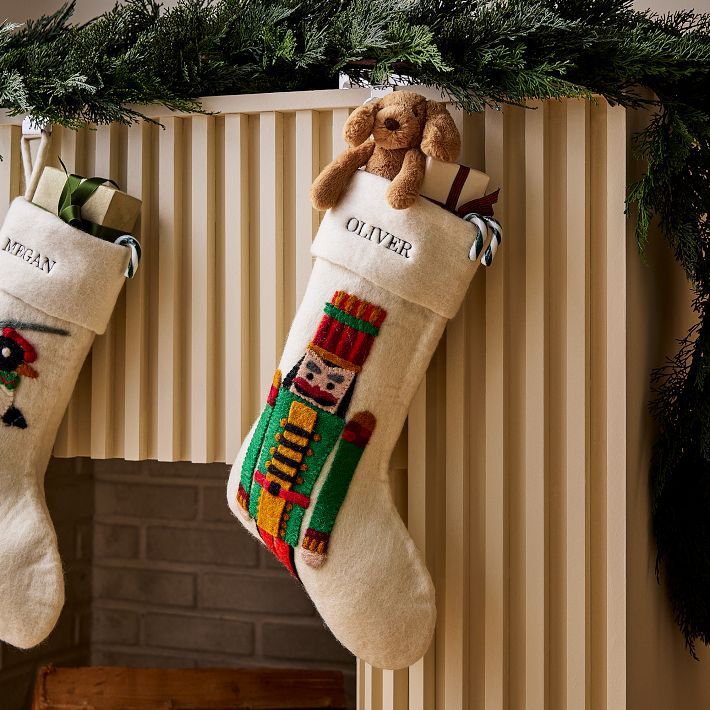 two christmas stockings hanging from a mantel decorated with teddy bears and other holiday decorations