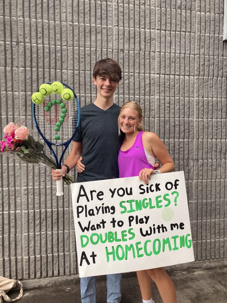 two people standing next to each other holding tennis rackets and a sign that says are you sick of playing singles? want to play doubles with me at homecombing