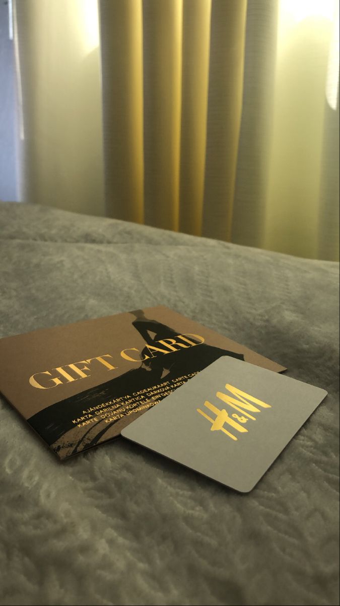 two books sitting on top of a bed next to each other in front of yellow curtains