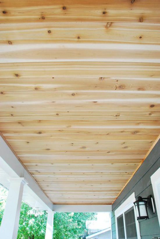 a porch covered with wooden planks and white trimming on the ceiling above it