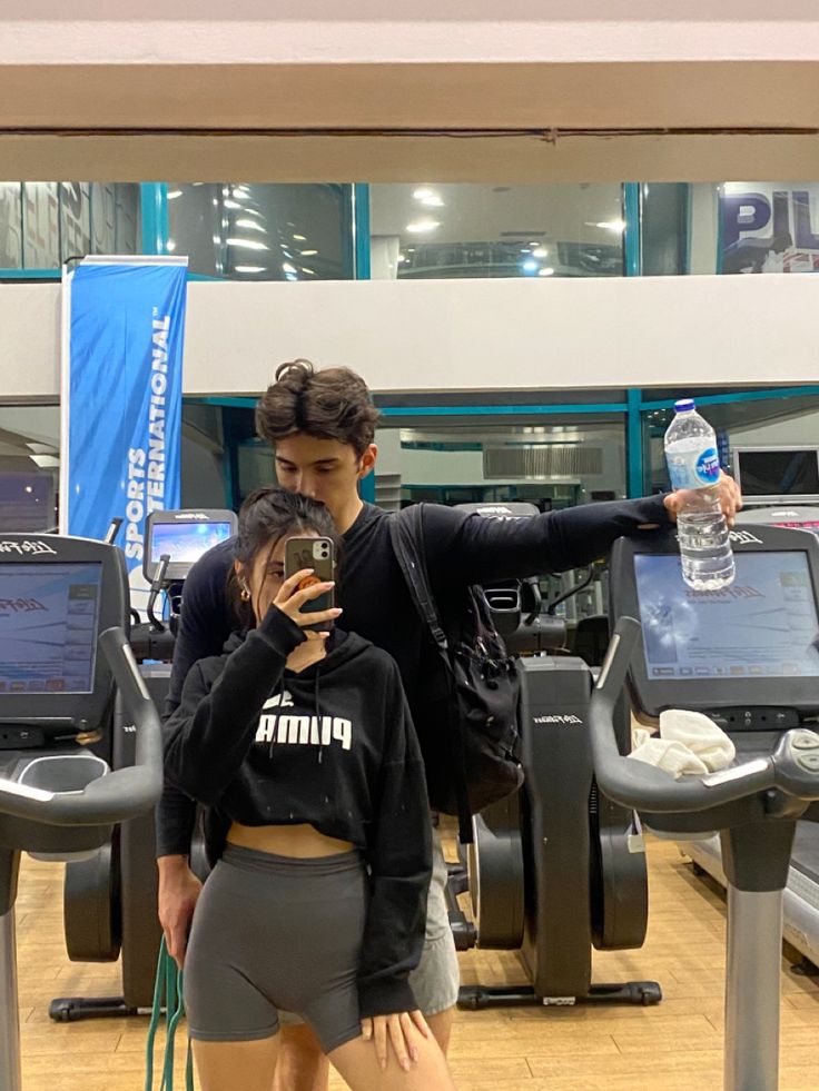 a woman taking a selfie with her cell phone at an airport check in counter