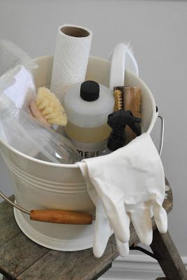 a bucket filled with cleaning supplies on top of a wooden table