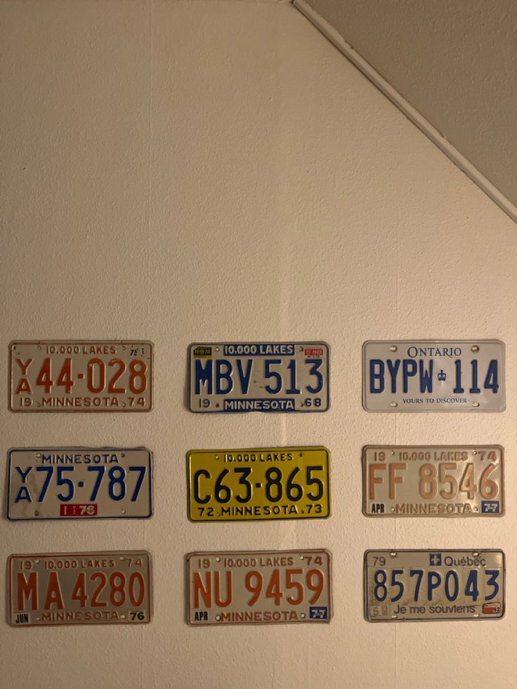 several license plates mounted to the wall in a room with white walls and ceilinging