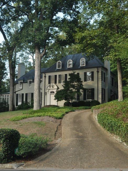 a large white house sitting on the side of a road