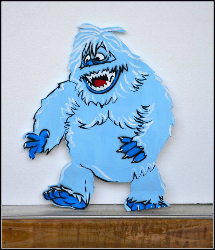 a paper cut out of a bigfoot standing on top of a wooden shelf in front of a white wall