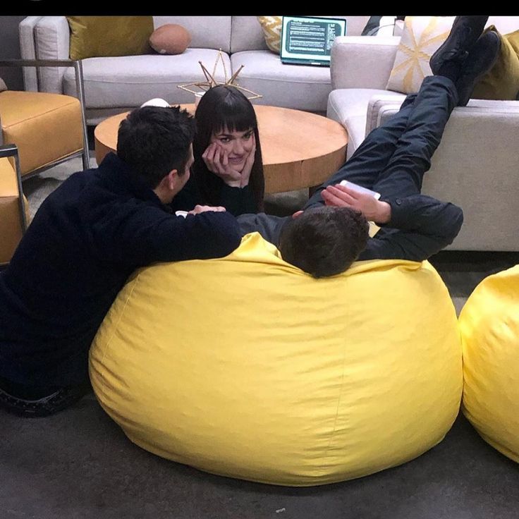 three people sitting on bean bag chairs in a living room