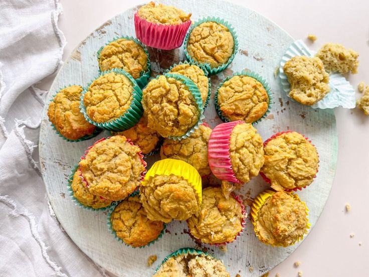 several muffins are on a plate with some crumbs next to them