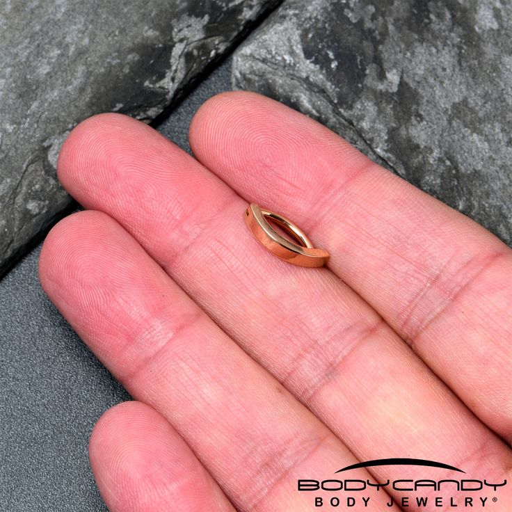 a person's hand holding a gold ring